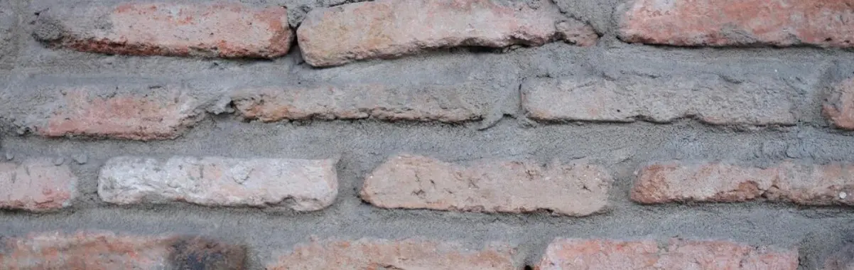 Deteriorated mortar joints on a Calgary brick wall before repair
