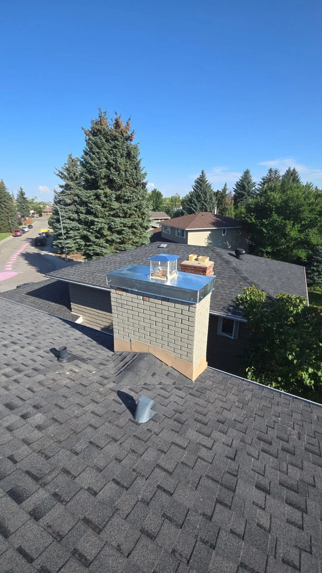 Finished custom galvanized chimney cap installation on a residential brick chimney in Calgary