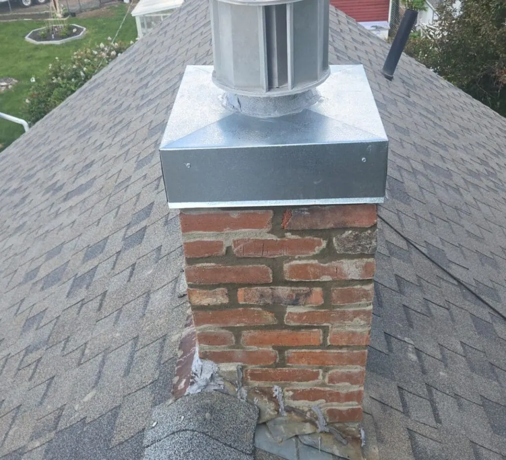 Freshly repointed brick chimney with new galvanized cap and flashing on a Calgary home