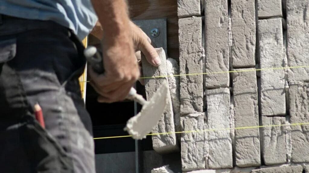 Professional masonry contractor working on a brick wall project.