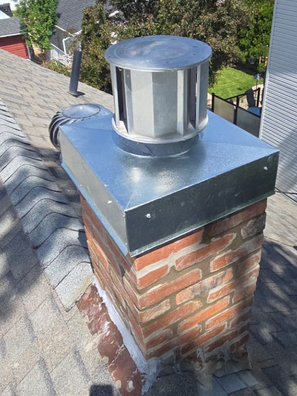 Professional chimney repair with a new chimney cap and restored brick masonry completed in Calgary.
